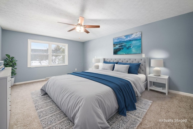 bedroom featuring light carpet, ceiling fan, a textured ceiling, and baseboards