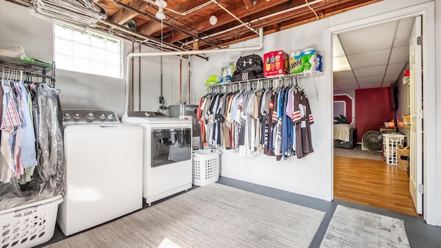 clothes washing area with separate washer and dryer and gas water heater