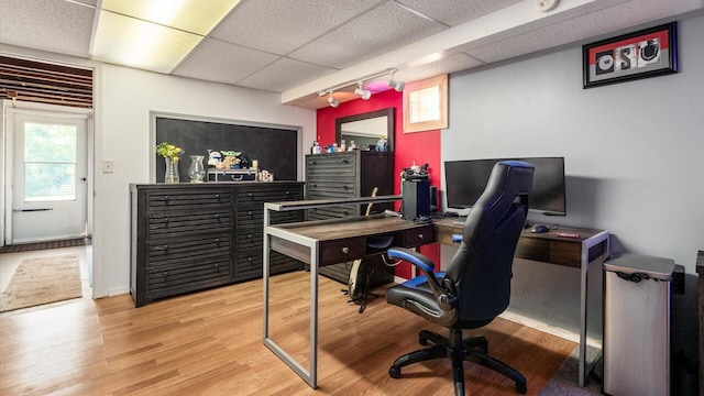 home office with a paneled ceiling and light wood-type flooring