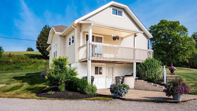 view of front facade featuring a balcony and a front yard