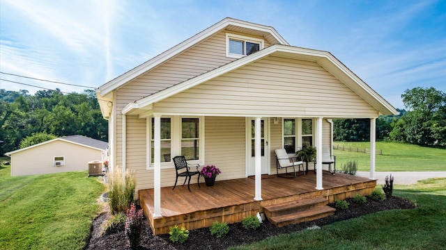 back of property with central AC unit, a porch, and a yard