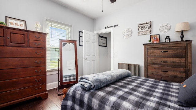 bedroom with ceiling fan, radiator heating unit, and dark wood-type flooring