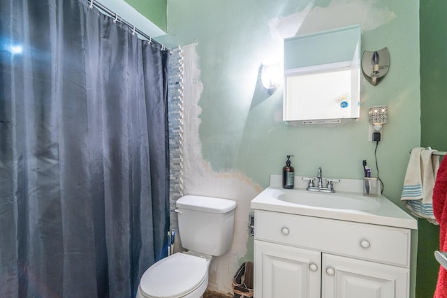 bathroom featuring toilet, vanity, and a shower with curtain