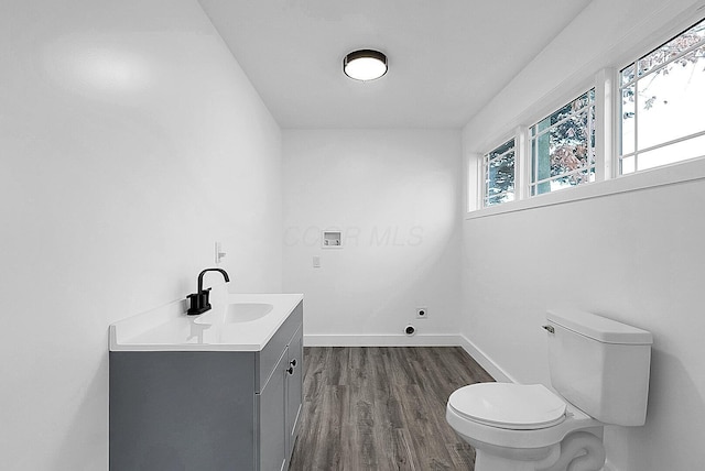 bathroom with toilet, vanity, and hardwood / wood-style flooring