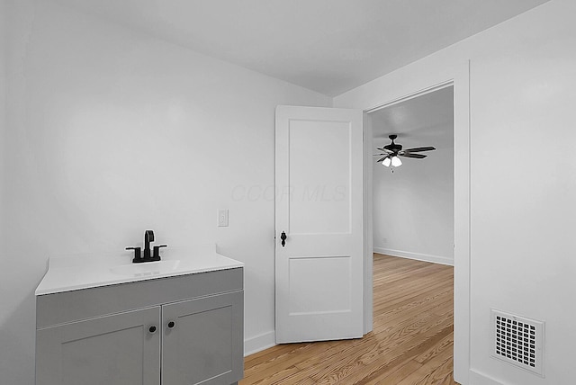 bathroom featuring ceiling fan, vanity, and wood-type flooring