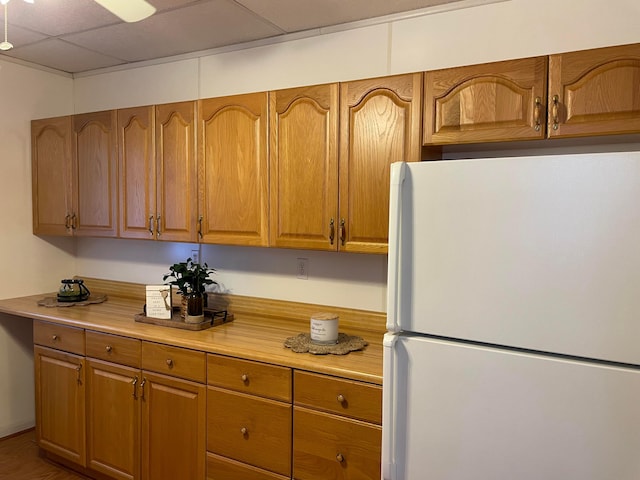 kitchen featuring a paneled ceiling and white refrigerator