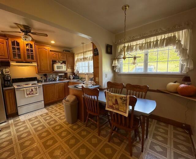 kitchen with ceiling fan, hanging light fixtures, and white appliances