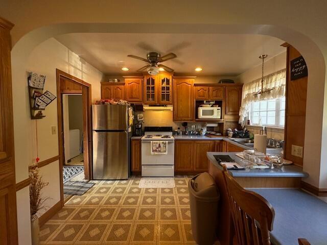 kitchen featuring sink, white appliances, hanging light fixtures, and ceiling fan