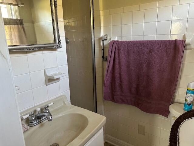 bathroom with decorative backsplash, vanity, tile walls, and toilet