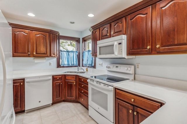 kitchen featuring light tile patterned flooring, white appliances, and sink