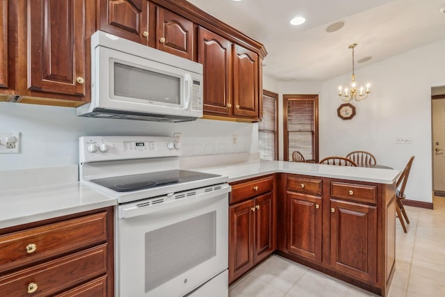 kitchen with kitchen peninsula, pendant lighting, a chandelier, white appliances, and light tile patterned floors