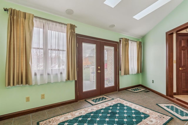 entryway with french doors, light tile patterned floors, and vaulted ceiling