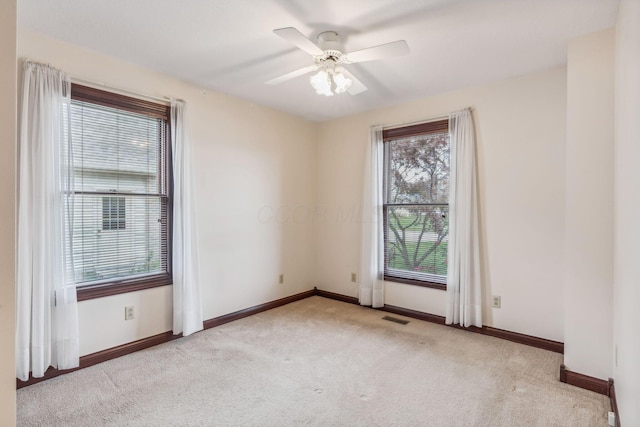 empty room with ceiling fan and light colored carpet