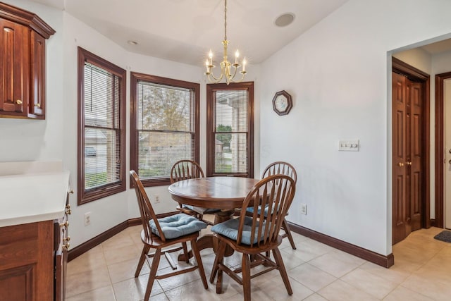 tiled dining space with a chandelier, lofted ceiling, and a healthy amount of sunlight