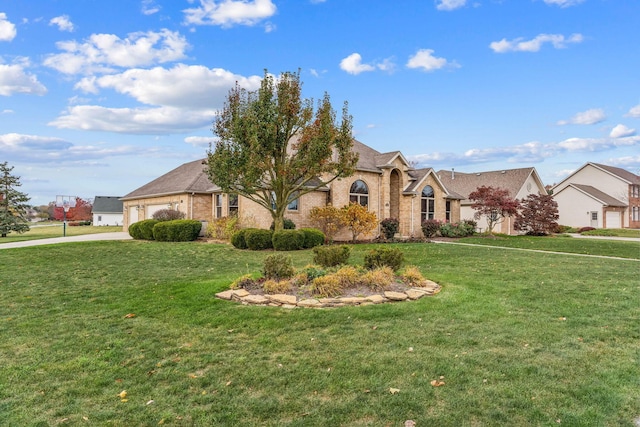 view of front facade featuring an attached garage, brick siding, driveway, and a front yard