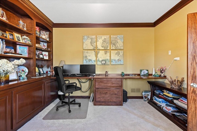 office featuring light colored carpet, built in desk, and crown molding