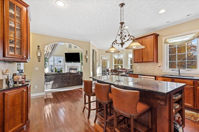 kitchen with a fireplace, a textured ceiling, dark hardwood / wood-style floors, and a kitchen island