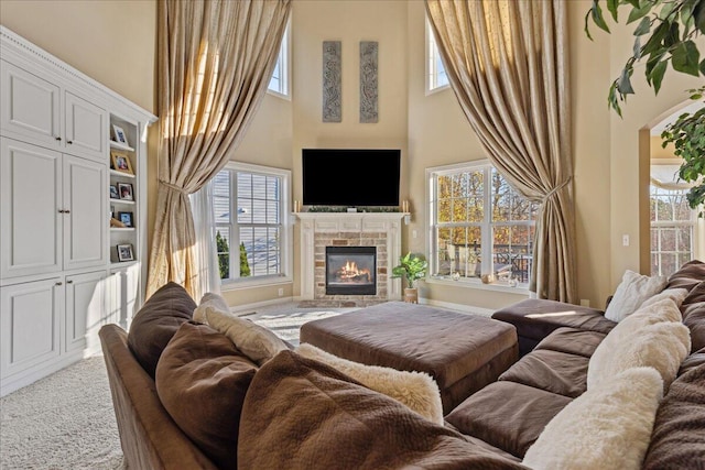 living room with a tile fireplace, carpet floors, and a healthy amount of sunlight