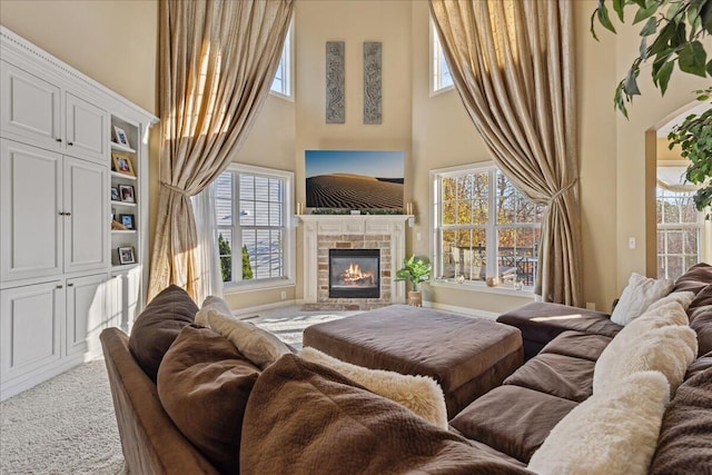 living room with carpet, a healthy amount of sunlight, and a tiled fireplace