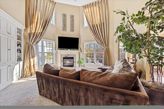 living room featuring carpet flooring, a high ceiling, and a tile fireplace