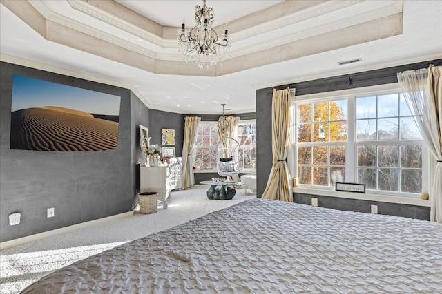 carpeted bedroom featuring a tray ceiling, a notable chandelier, and ornamental molding