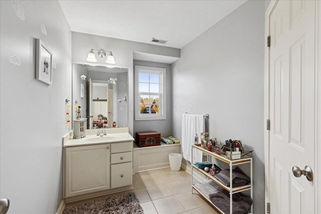 bathroom featuring tile patterned flooring, vanity, and a textured ceiling