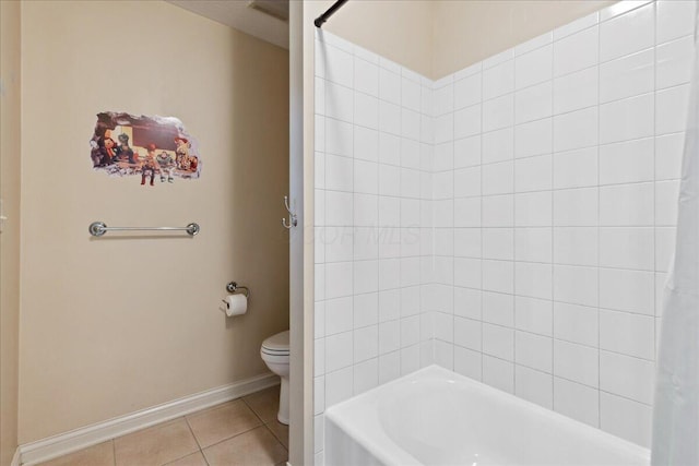 bathroom featuring tile patterned floors, tiled shower / bath combo, and toilet