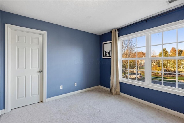 unfurnished room featuring light carpet