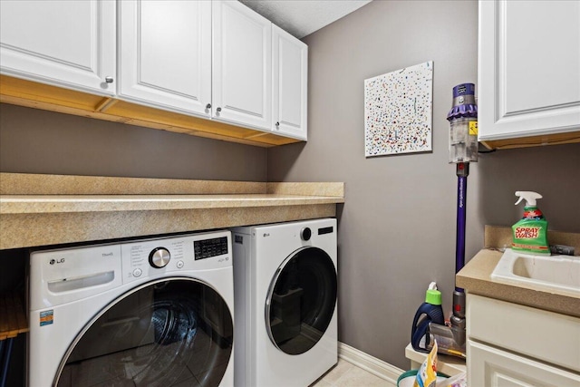 laundry area featuring cabinets, light tile patterned floors, and separate washer and dryer