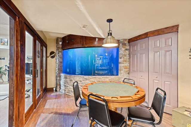 dining room featuring french doors and light hardwood / wood-style flooring