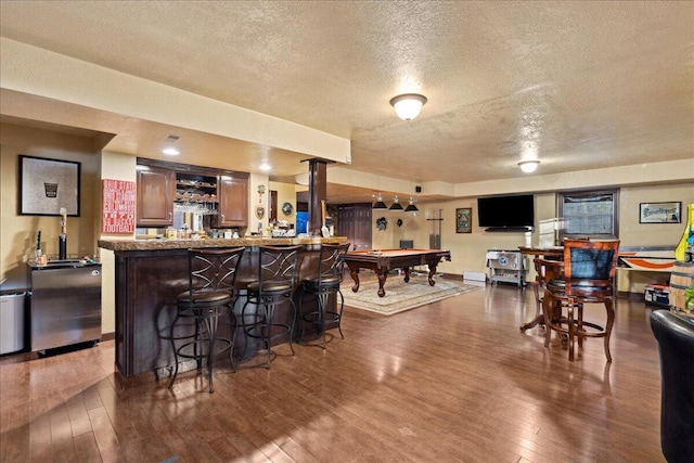 bar featuring dark hardwood / wood-style flooring, a textured ceiling, and billiards