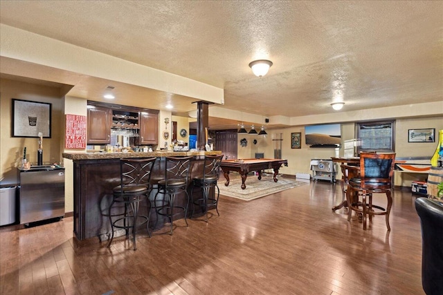 bar with a textured ceiling, dark hardwood / wood-style floors, and billiards