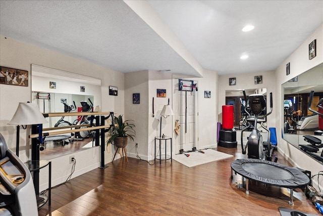 workout area with wood-type flooring and a textured ceiling