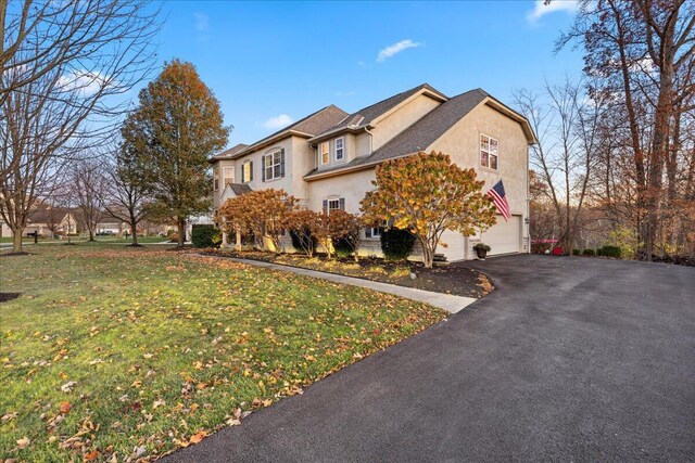 view of front of property featuring a garage and a front lawn