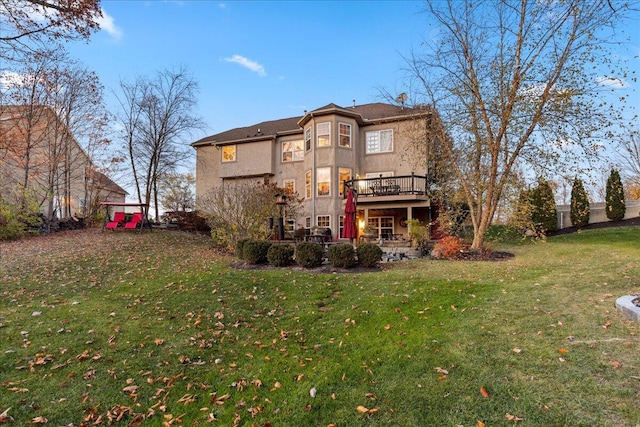 rear view of property with a lawn and a wooden deck