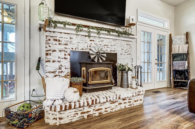 details with a wood stove, french doors, and wood-type flooring