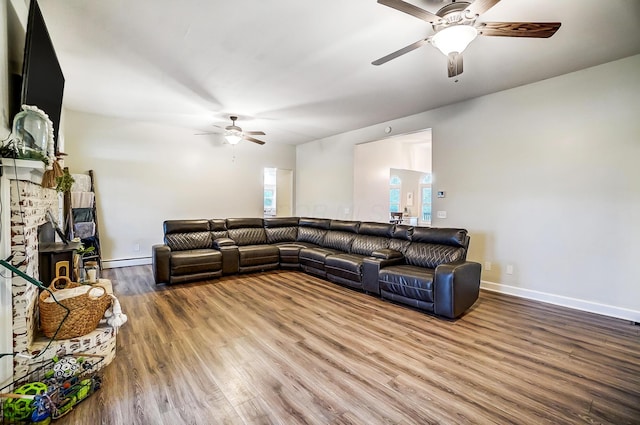 living room featuring wood-type flooring, a baseboard radiator, and ceiling fan