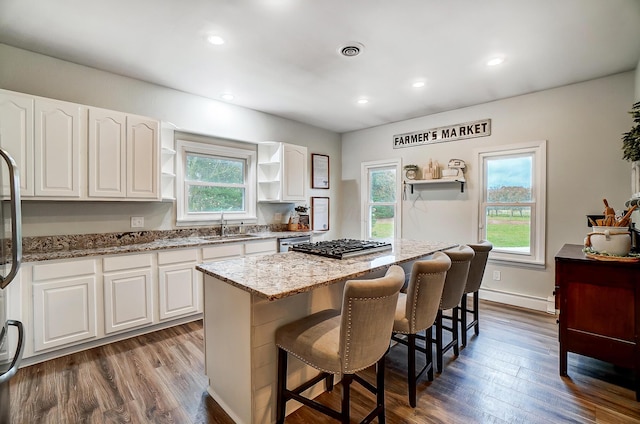 kitchen featuring a center island, white cabinetry, dark wood-type flooring, and sink