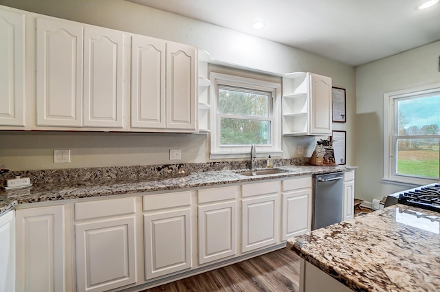 kitchen with plenty of natural light, dark stone countertops, white cabinetry, and sink