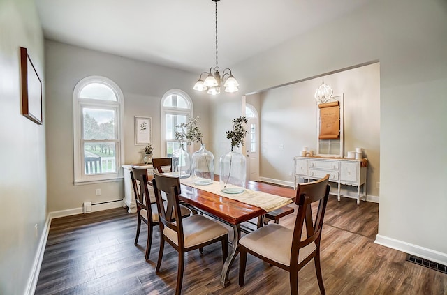 dining room with dark hardwood / wood-style floors, baseboard heating, and an inviting chandelier