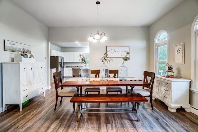 dining area with dark wood-type flooring and a notable chandelier