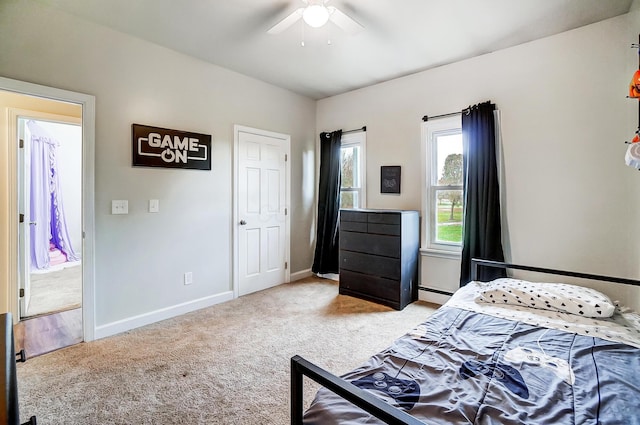 bedroom with ceiling fan, light colored carpet, and a baseboard radiator