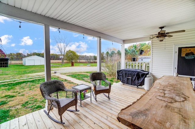 wooden deck featuring a yard and ceiling fan