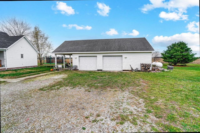 garage featuring a yard and a carport