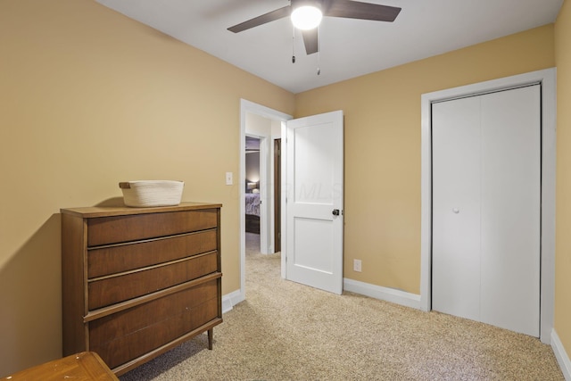 carpeted bedroom featuring ceiling fan and a closet