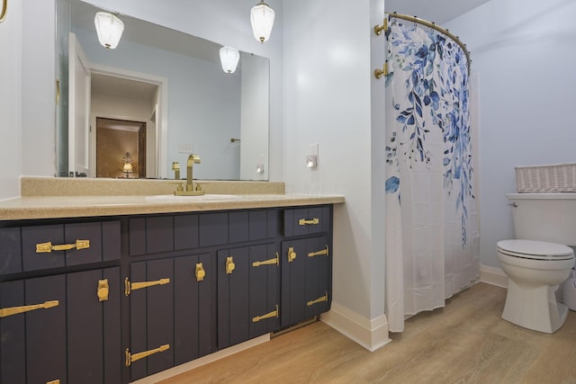 bathroom featuring a shower with curtain, wood-type flooring, toilet, and vanity