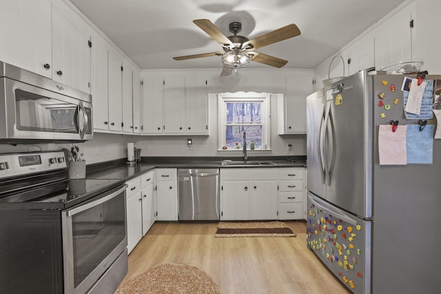 kitchen featuring sink, ceiling fan, stainless steel appliances, light hardwood / wood-style floors, and white cabinets