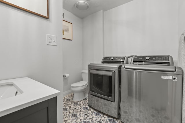 washroom with washing machine and dryer and a textured ceiling