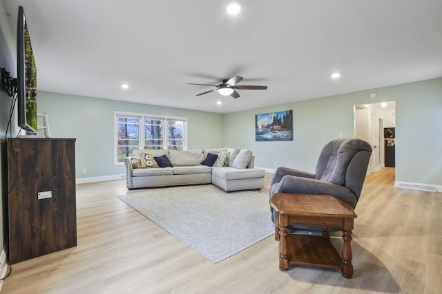 living room featuring light hardwood / wood-style floors and ceiling fan