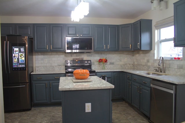 kitchen with sink, a center island, light stone counters, decorative backsplash, and appliances with stainless steel finishes